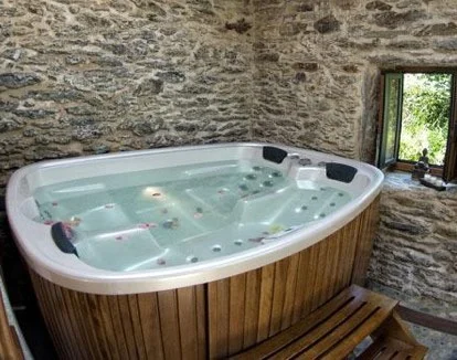 Jacuzzi para 4 personas en la casa de 3 dormitorios en Opino en el hotel rural Molino A Maquía de Medín en la provincia de A Coruña