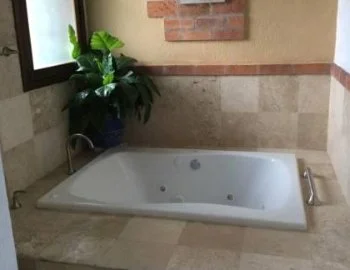 Foto y detalle de jacuzzi en la Suite con cama grande y bañera de hidromasaje.