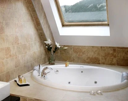 habitación con bañera de hidromasaje en el baño bajo boardilla