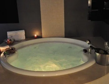 Foto del interior de la Suite Superior con bañera de hidromasaje y sauna .