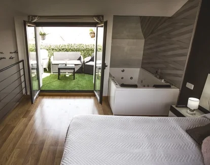 Foto de la la Habitación Deluxe con cama grande donde se encuentra la bañera de hidromasaje.