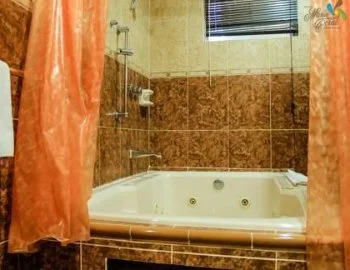 Vista del interior de la Habitación Doble Superior con cama grande y vistas al océano en donde puedes disfrutar con tu pareja de tu propia bañera de hidromasaje.