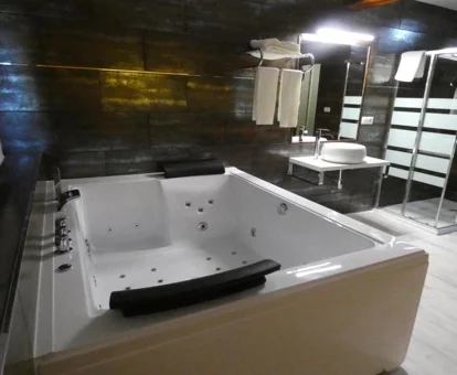 La Habitación con cama grande y bañera de hidromasaje y su jacuzzi privado.
