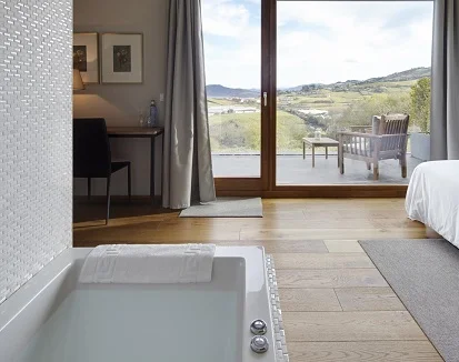 Suite con bañera de hidromasaje en el encantador hotel rural entre viñedos Hotel San Prudentzio. Perfecto para escaparte un fin de semana y disfrutar de este elegante hotel rural de Guipuzcoa