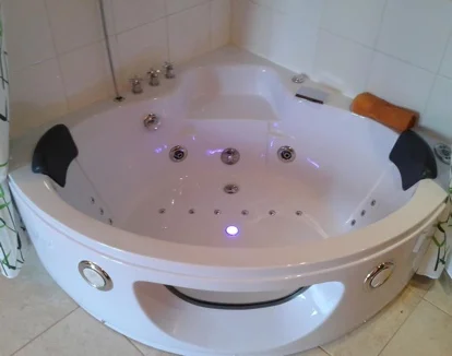 Suite con jacuzzi junto a la cama en el hotel Pasteral en la población de La Cellera de Ter en la provincia de Girona.