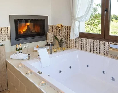 Habitación muy romántica con jacuzzi junto a la chimenea en el hotel El Racó de Madremanya en la provincia de Girona