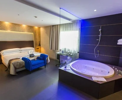 Jacuzzi de forma circular que se encuentra frente a la cama en la suite con bañera de hidromasaje en el Félix Hotel Residencia