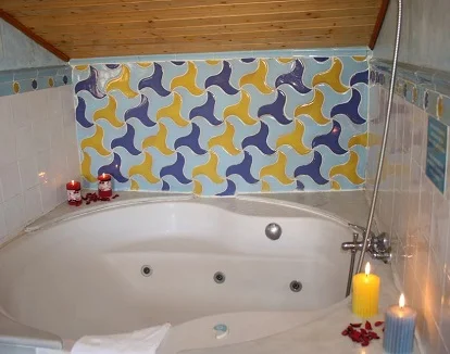 Foto del jacuzzi que puedes encontrar en el baño bajo un techo de madera en la suite del hotel Abadía de la ciudad de Granada