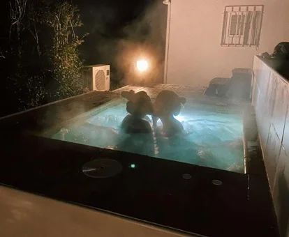 Foto de una pareja por la noche en el jacuzzi exterior de la casa rural Ca l'Eli