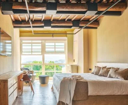 Una de las acogedoras habitaciones con mucha luminosidad, amplios ventanales y vistas a los alrededores.