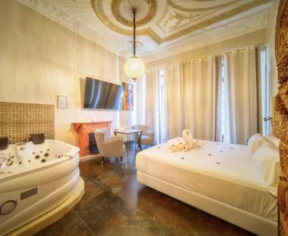 Una de las habitaciones dobles de un elegante estilo con jacuzzi privado junto a la cama.
