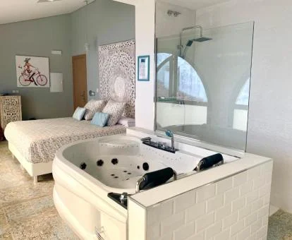 Una de las preciosas habitaciones dobles con jacuzzi privado junto a la cama del hotel. 