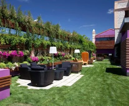 Colorida zona exterior con jardín y mobiliario de este moderno hotel.