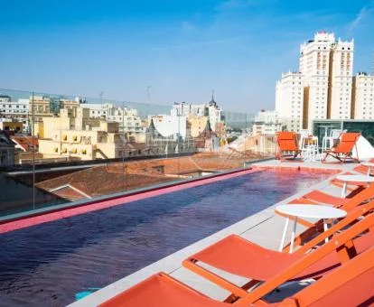 Piscina con solarium y vistas a la ciudad el hotel.