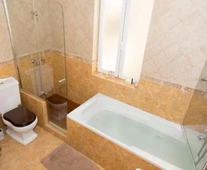 Baño con bañera de hidromasaje privada llena de agua del apartamento dúplex.
