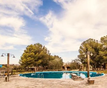 Zona exterior con piscina rodeada de vegetación de este hotel.
