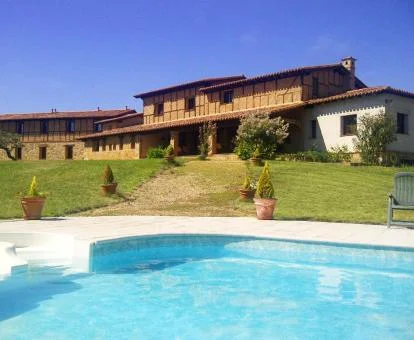 Hermoso hotel rural con una amplia piscina exterior y jardines.