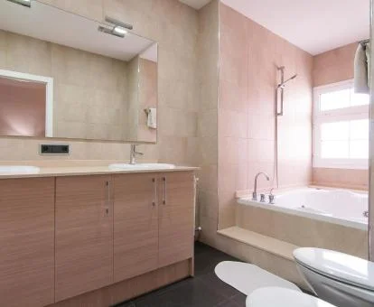 Amplio baño con bañera de hidromasaje privada del apartamento de un dormitorio de este establecimiento.