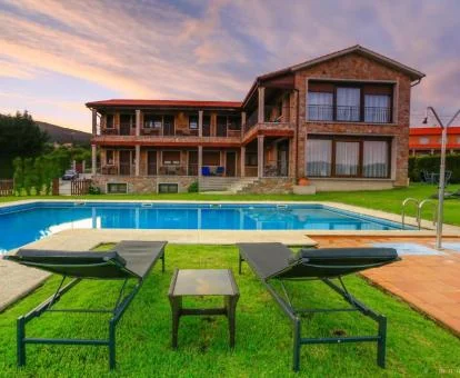 Edificio rústico rodeado de amplios jardines con piscina de este acogedor hotel boutique.