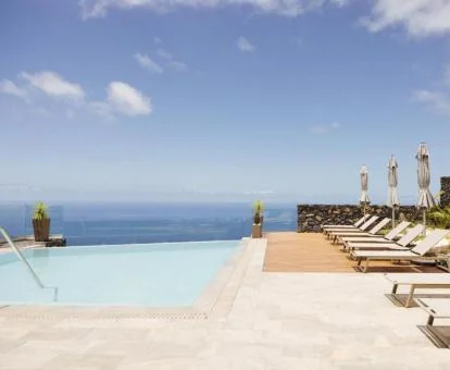Preciosa piscina de borde infinito con vistas y solarium de este hotel con encanto.