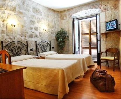 Una de las cómodas habitaciones con paredes de piedra a la vista del hotel.