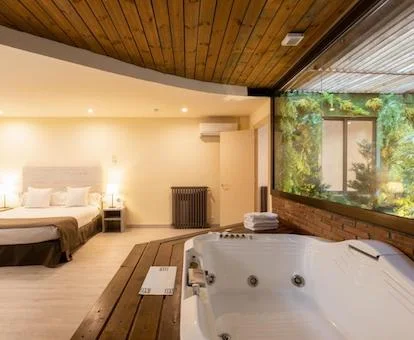 Jacuzzi frente a la cama en el apartamento y junto a la ventana del jardín interior