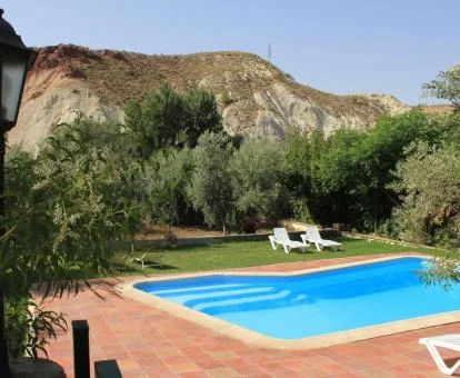 Zona exterior con piscina y vistas a las montañas que rodean el complejo de apartamentos.
