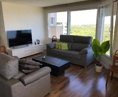 Sala de estar con vistas a la vegetación de los alrededores de este apartamento independiente.