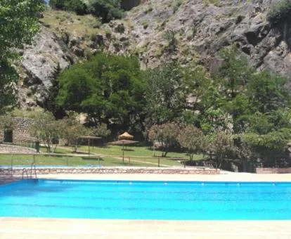 Piscina exterior rodeada de naturaleza de este complejo de apartamentos.