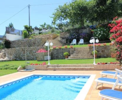 Piscina exterior con solarium y bellos jardines.