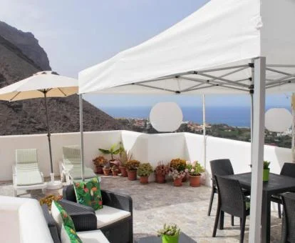 Terraza privada con vistas al mar y mobiliario exterior de uno de los apartamentos.