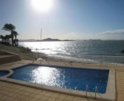 Piscina exterior con vistas al mar de este complejo de apartamentos a pie de playa.