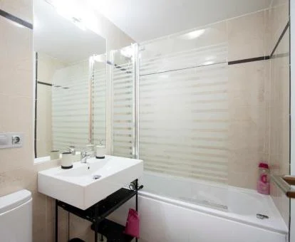 Baño con bañera de hidromasaje privada de este apartamento con vistas al mar.
