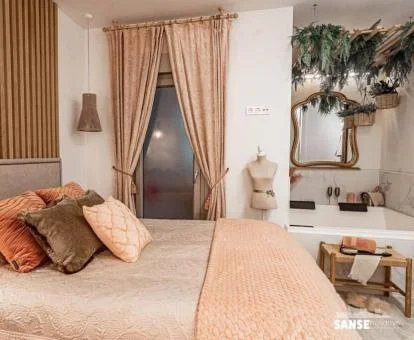 Dormitorio con un amplio jacuzzi junto a la cama de este apartamento independiente.