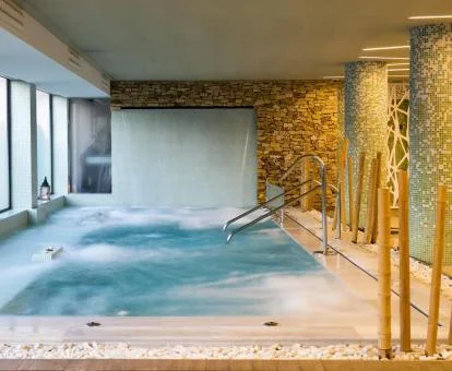 Piscina cubierta con elementos de hidroterapia del spa del hotel.