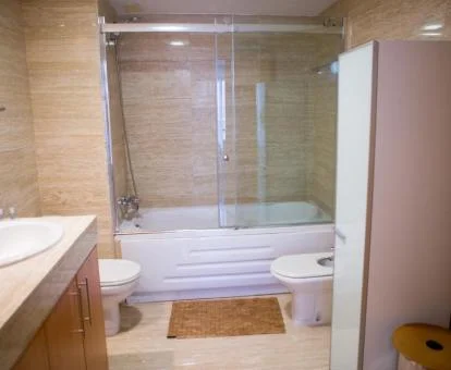 Baño con bañera de hidromasaje privada de este moderno apartamento.