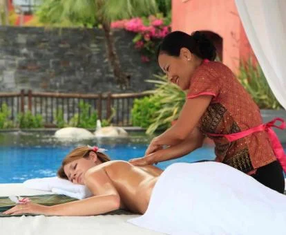 Mujer disfrutando de un masaje al aire libre en este espectacular hotel.
