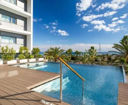 Piscina exterior con vegetación y vistas al mar de este hotel solo para adultos.