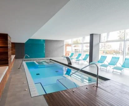 Piscina cubierta con hidroterapia y vistas al exterior del spa.