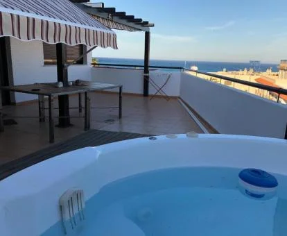 Terraza con un amplio jacuzzi privado y vistas al mar de este apartamento independiente.