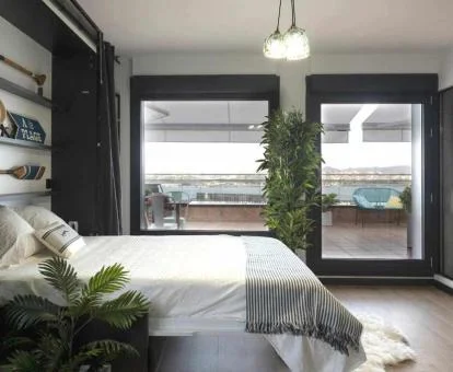 Dormitorio con amplios ventanales y fabulosas vistas de este ático de lujo con jacuzzi.