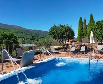 Piscina exterior con elementos de hidroterapia y vistas a la naturaleza del hotel.