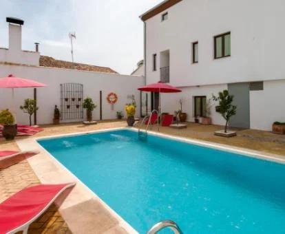 Acogedor hotel boutique con piscina al aire libre con solarium y tumbonas.