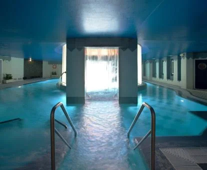 Piscina cubierta con elementos de hidroterapia del spa del hotel.