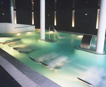 Piscina cubierta con elementos de hidroterapia del spa del hotel.