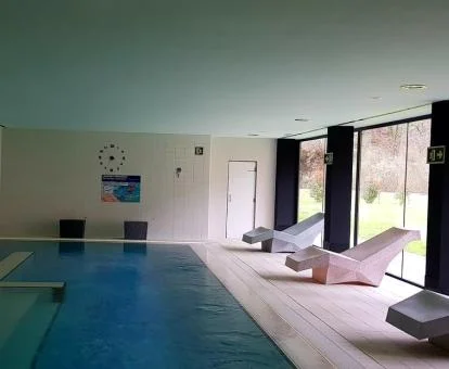 Piscina cubierta con vistas a la naturaleza y zona de relajación del spa del hotel.