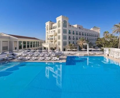 Espectacular hotel de playa con una gran piscina al aire libre.