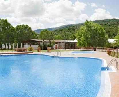 Gran piscina rodeada de vegetación de este precioso hotel.