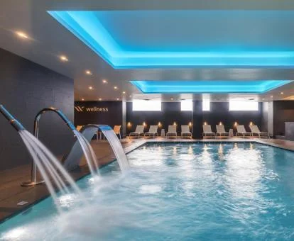Piscina cubierta con elementos de hidroterapia del spa del hotel.