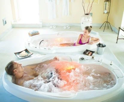 Pareja disfrutando de la zona de aguas del spa del hotel.
